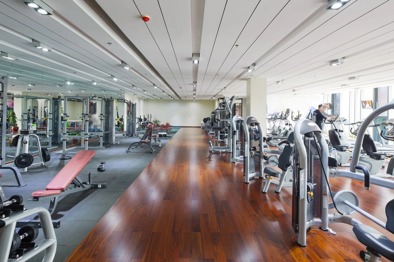 A gym with many machines and wooden floors